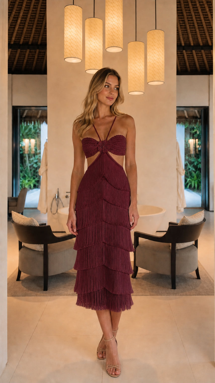 Front full view of woman wearing burgundy halter cut-out tiered fringe midi dress