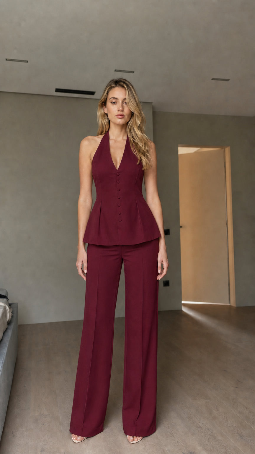 Model wearing burgundy halter peplum vest and wide-leg pants set