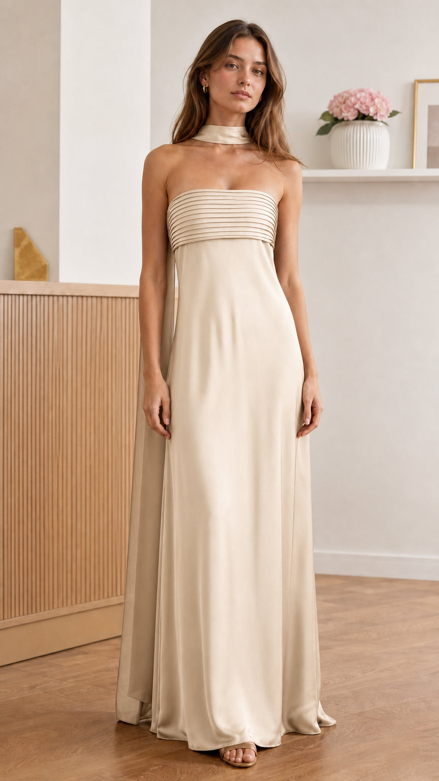 Front view of model wearing champagne pleated strapless maxi dress