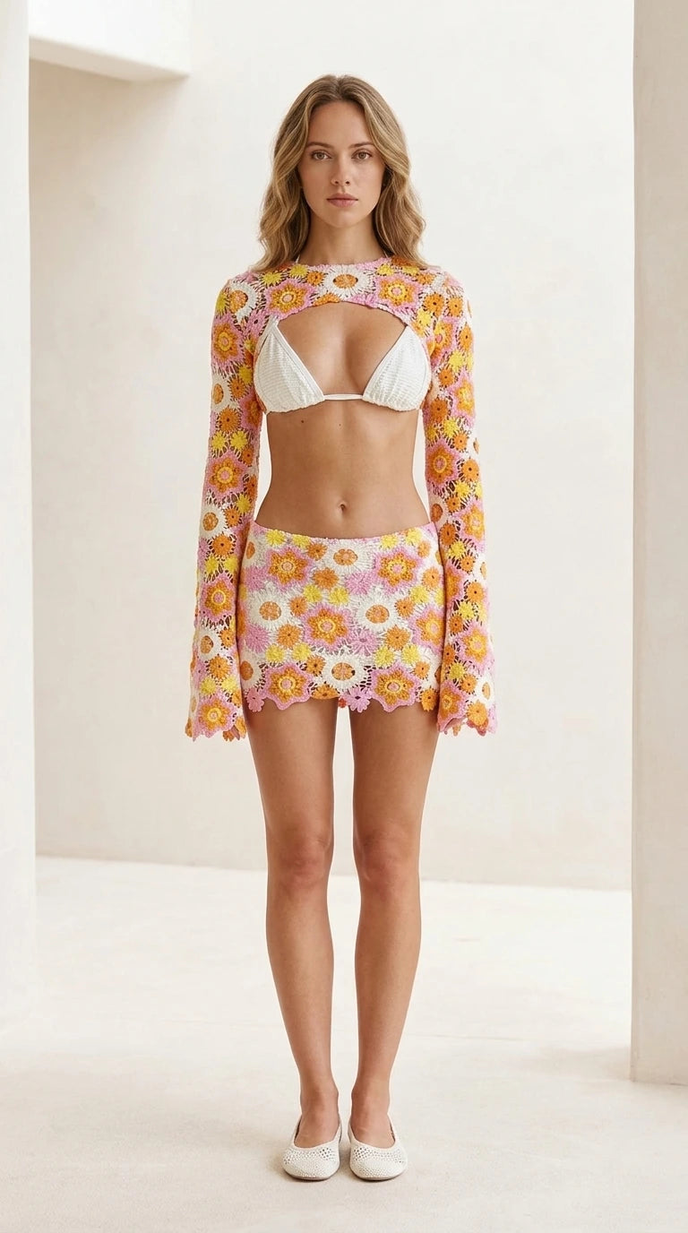 Front view of model wearing pink floral crochet shrug and mini skirt set