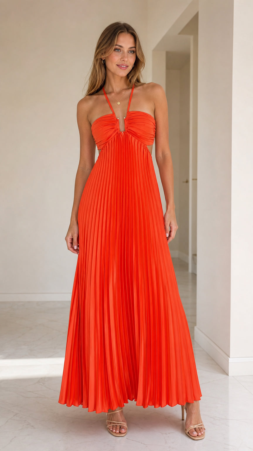 Front view of model wearing vibrant orange halter pleated maxi dress