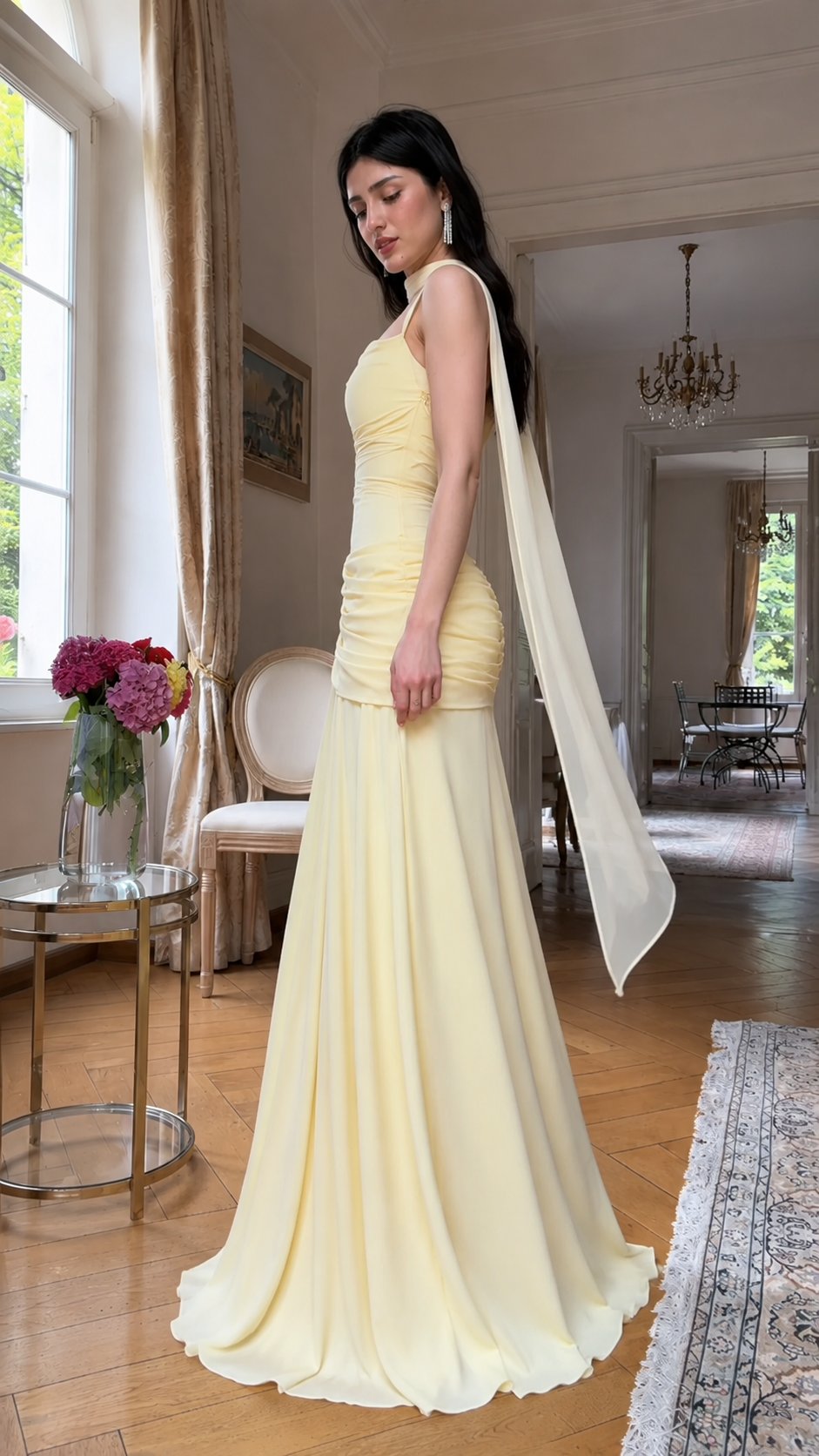 Side view of butter yellow ruched maxi evening dress with trailing scarf neckline