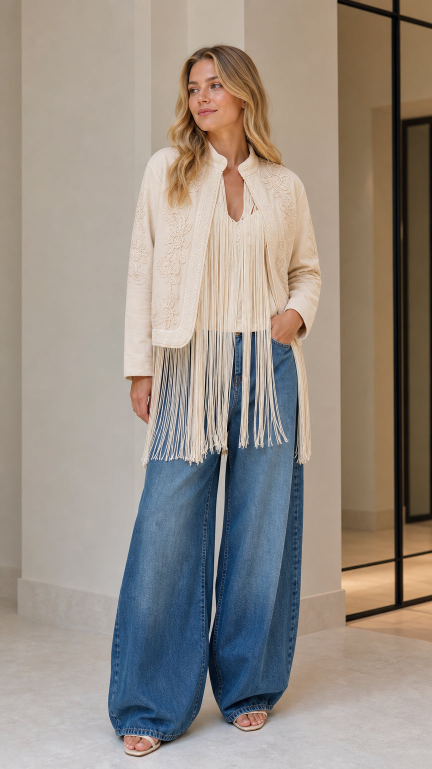 Model wearing beige embroidered fringe jacket, front view