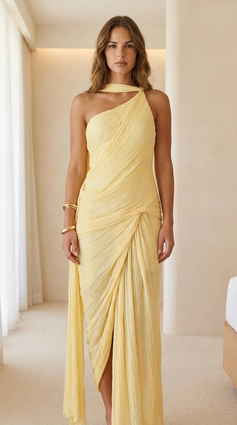 Front view of woman wearing yellow one-shoulder pleated maxi dress
