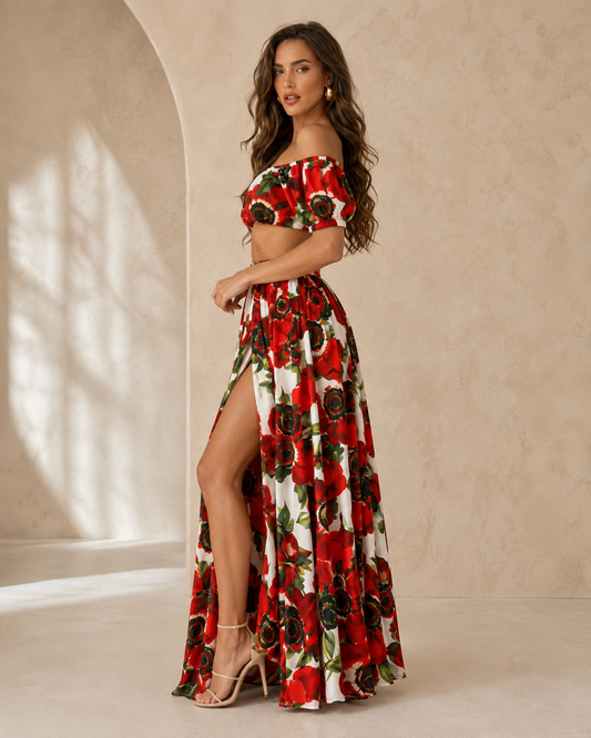 Woman wearing a red floral off shoulder crop top and high slit maxi skirt set front side view