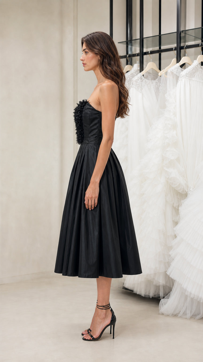 Side view of model wearing black strapless midi dress