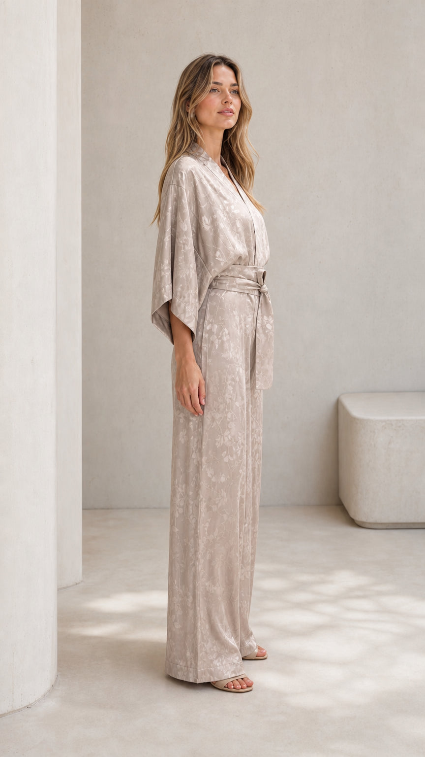 Side profile of woman wearing champagne satin jumpsuit