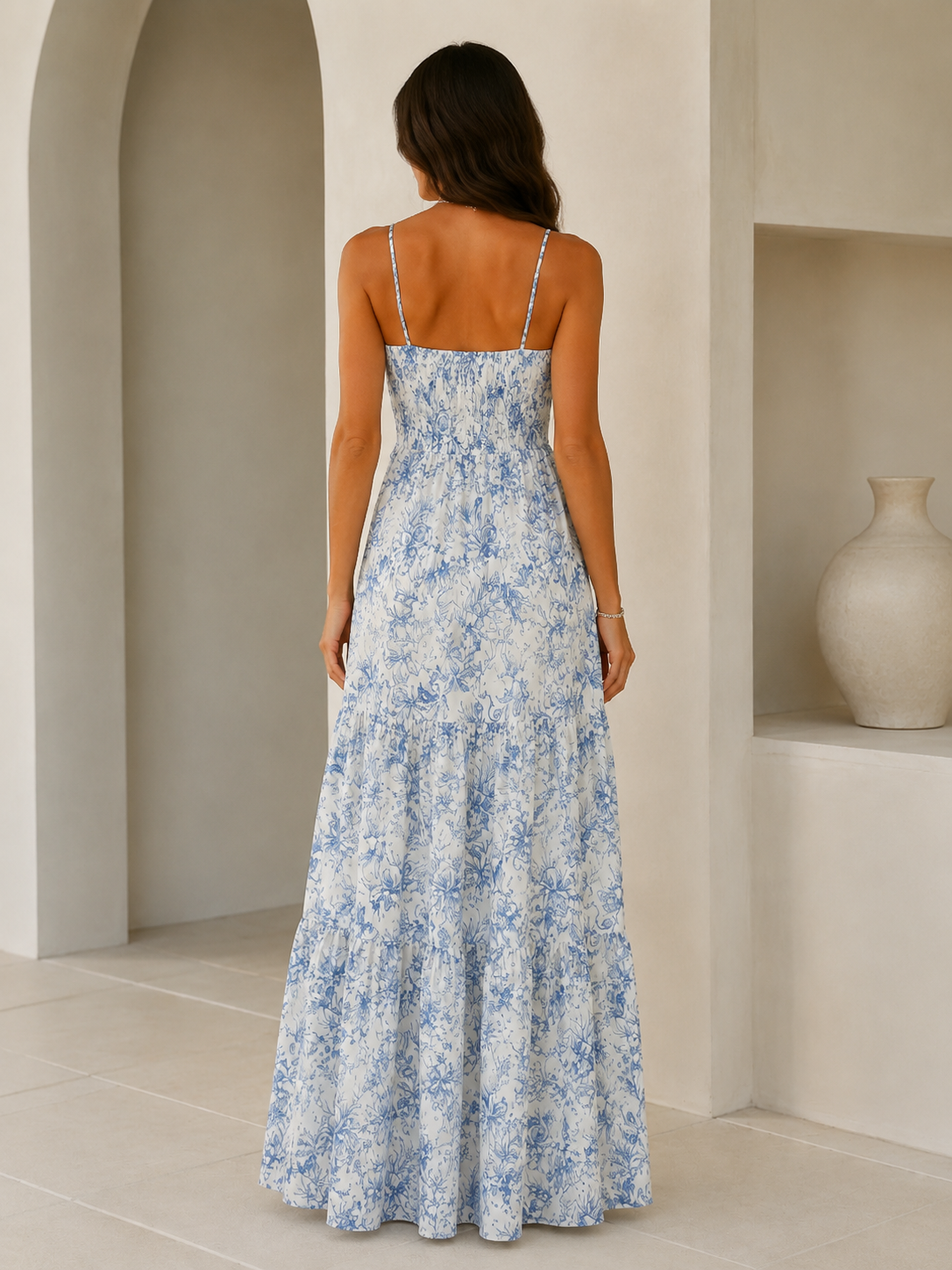 Back view of blue printed smocked spaghetti strap tiered maxi dress