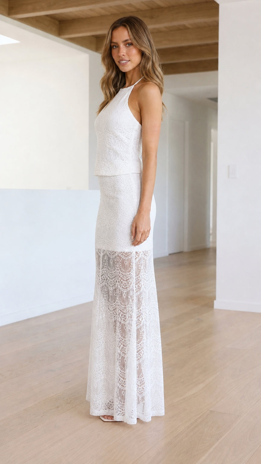 Side profile of model in white lace maxi dress