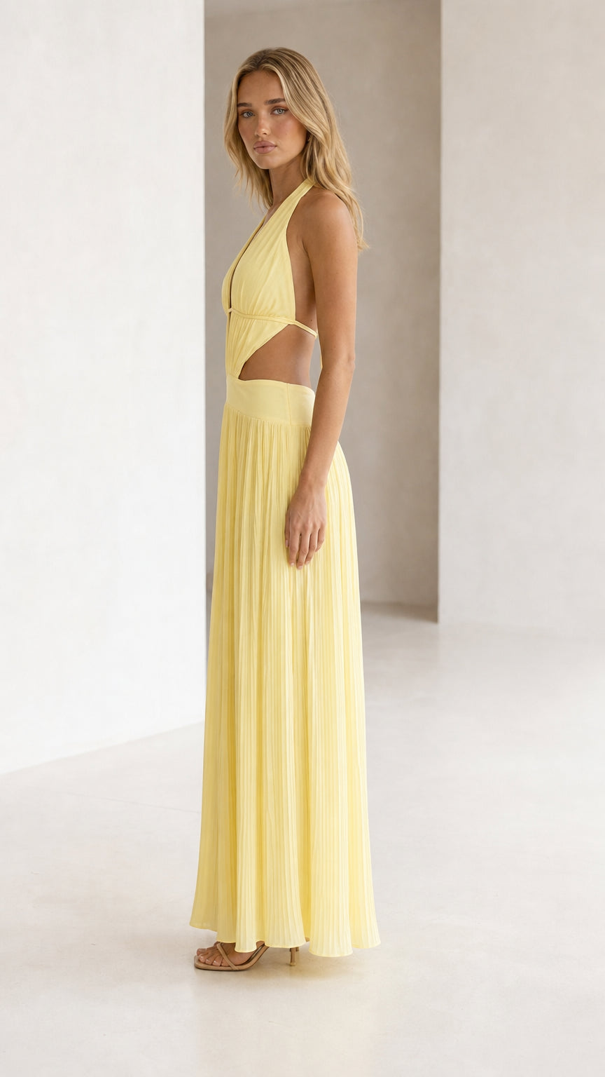 Side view of yellow halter neck cutout pleated maxi dress