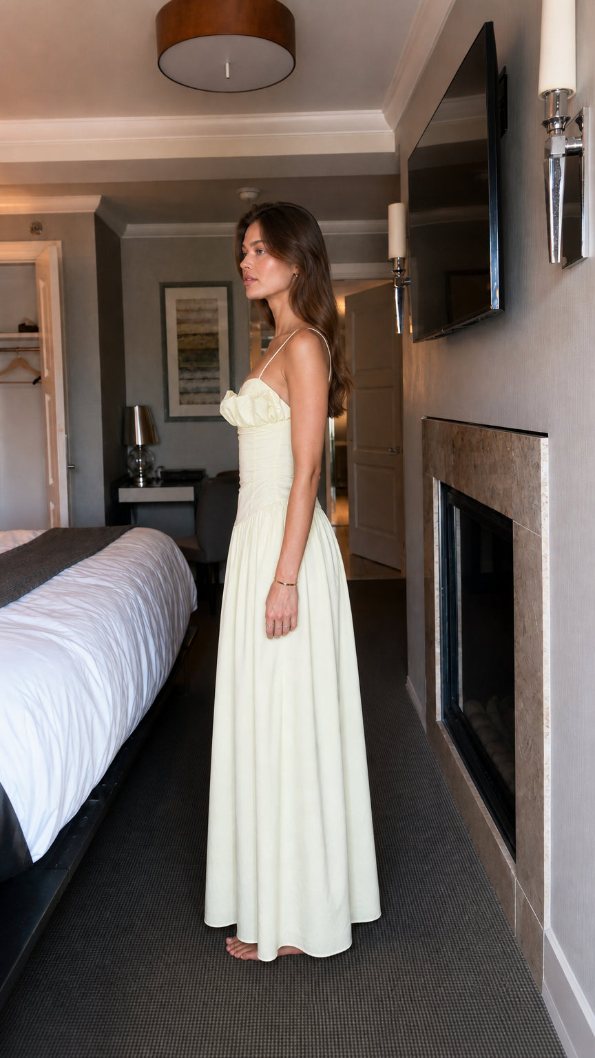 Side view of woman wearing light yellow ruffled maxi dress