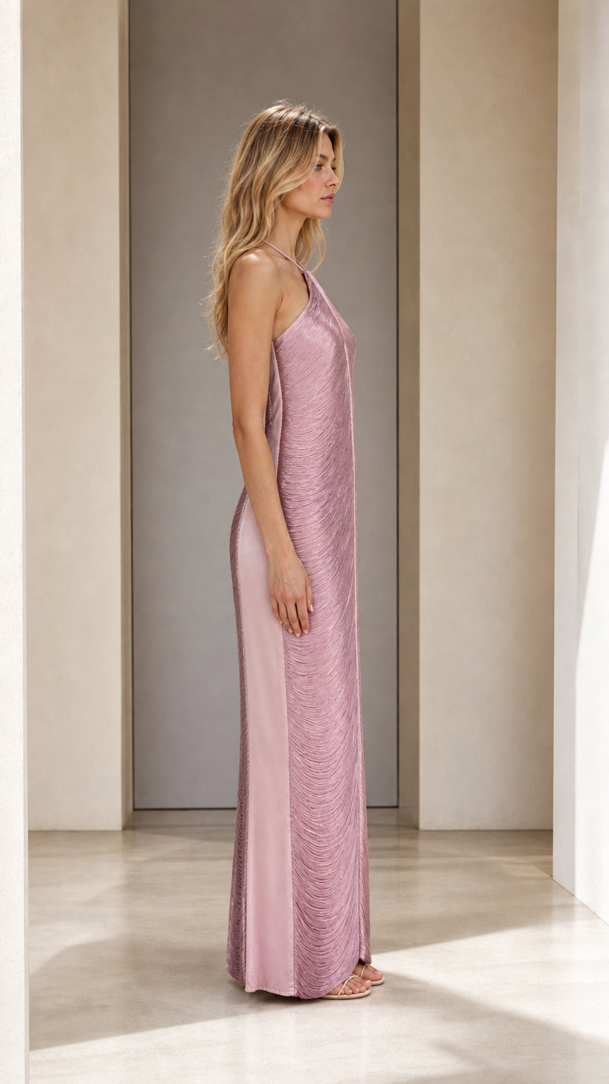 Side profile of model in mauve pleated maxi dress