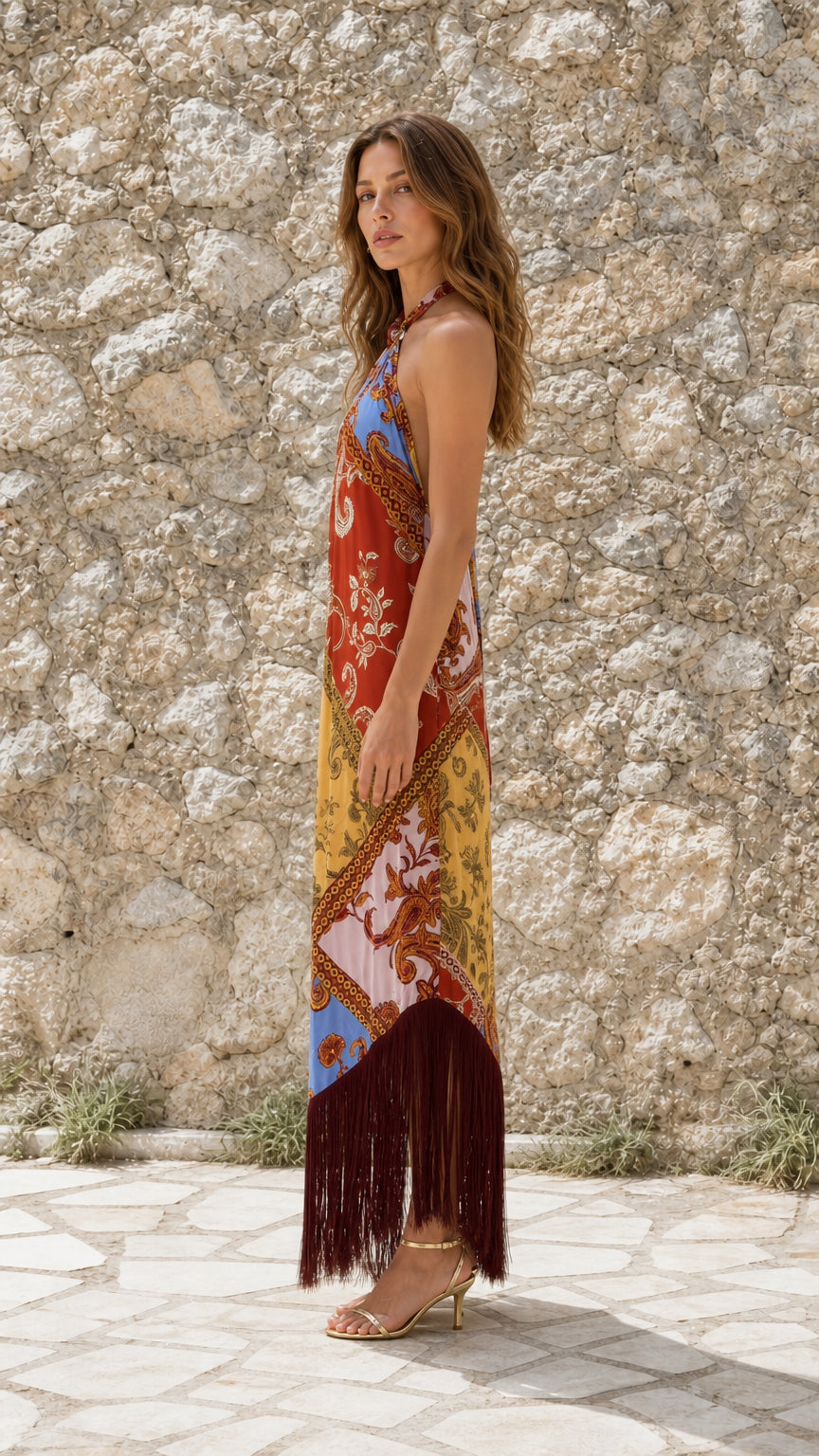 Side view of model wearing Multicolor paisley halter fringe maxi dress