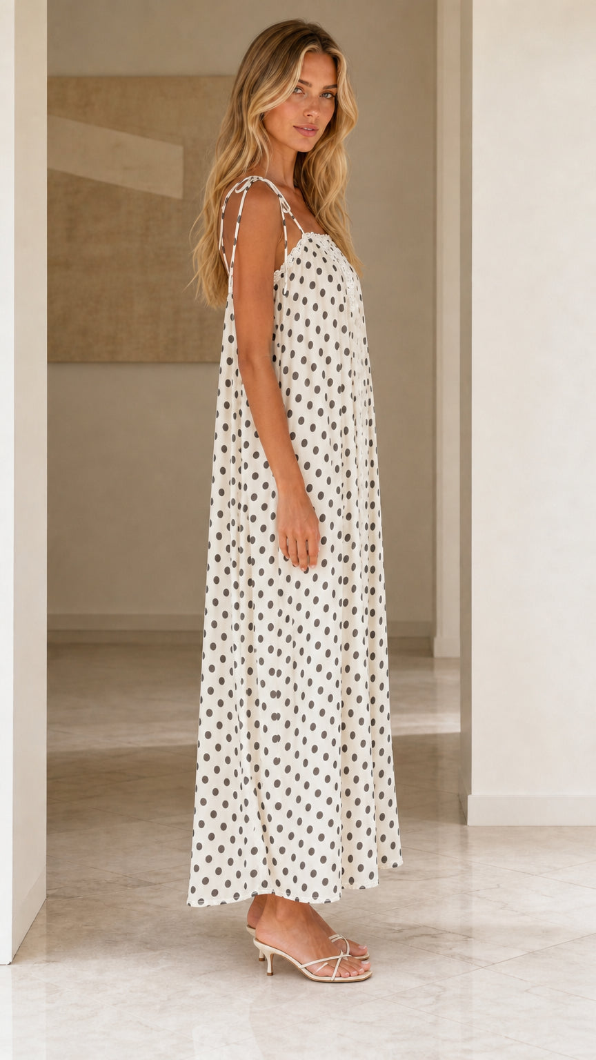 Side view of woman wearing white polka dot maxi dress