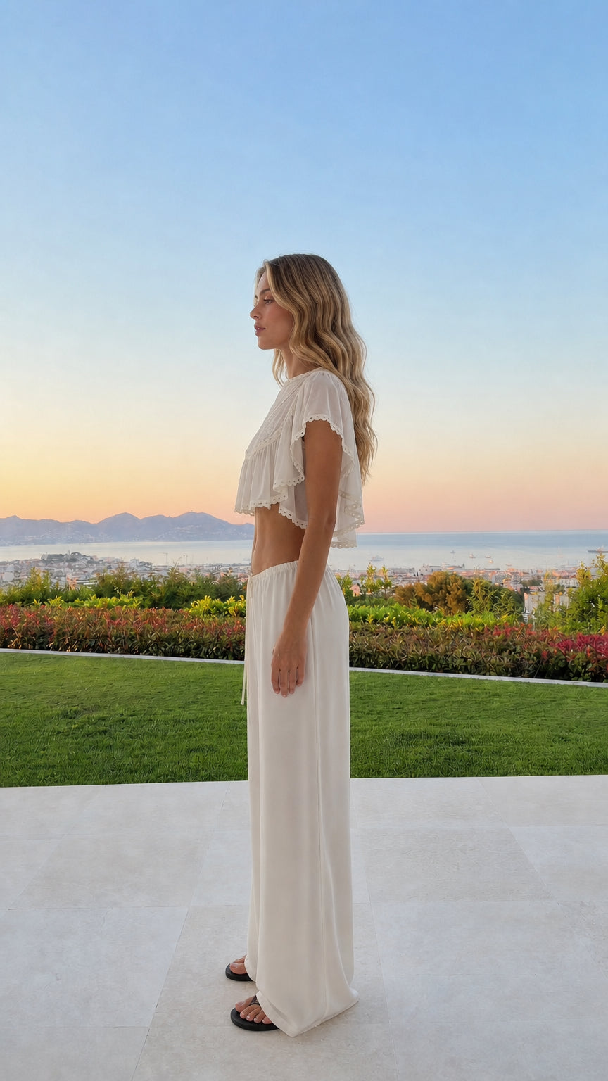 Side view of woman wearing white two-piece lounge set outdoors