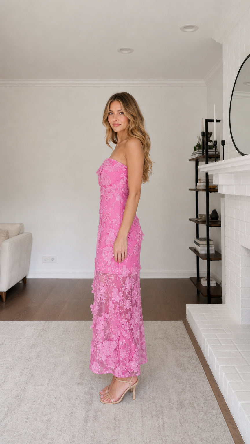 Side profile view of model in pink strapless maxi dress