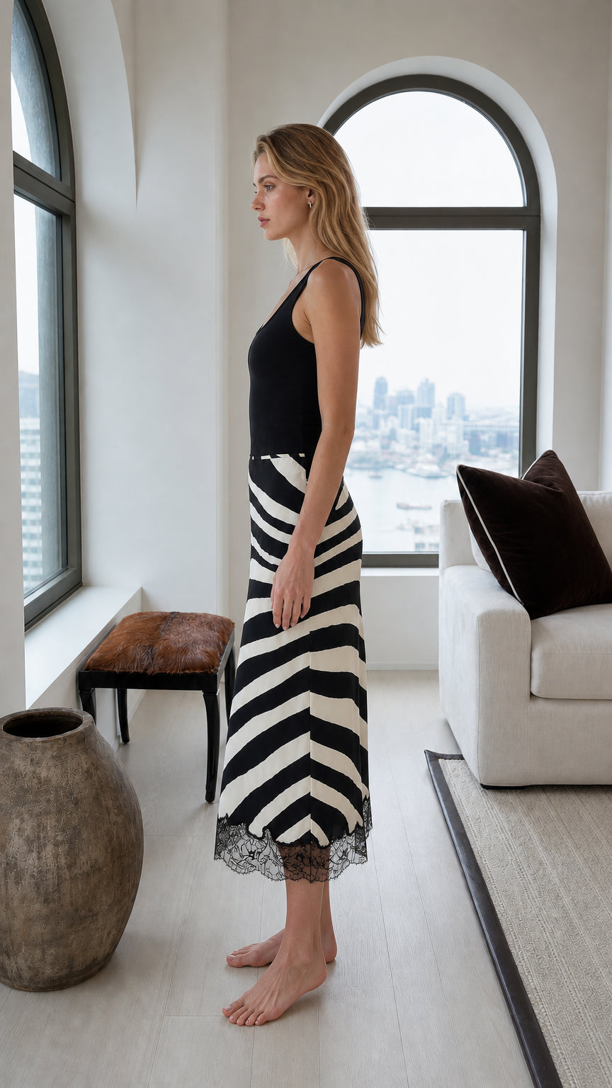 Side view showing the fitted silhouette of a black and white zebra print midi skirt