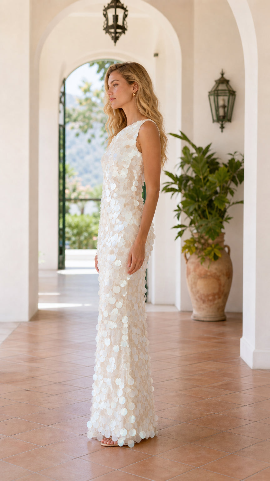 Side profile of model in white sequin evening dress