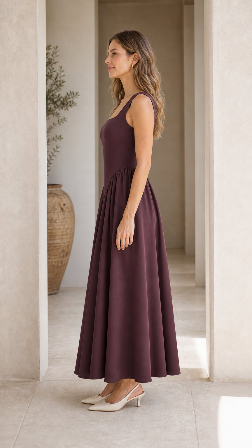 Side profile view of woman in burgundy maxi dress