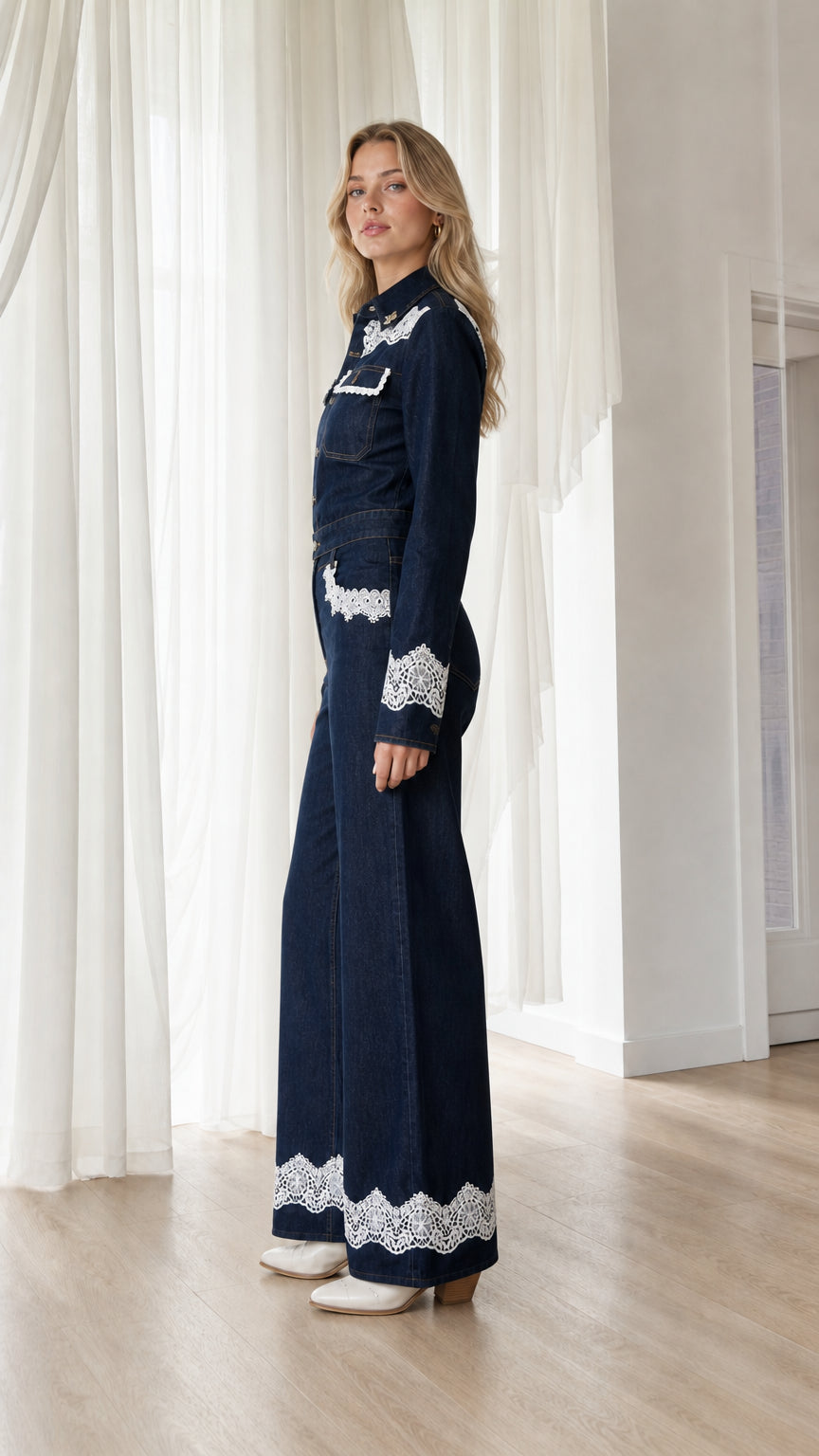 Side profile view of dark denim jumpsuit with wide leg