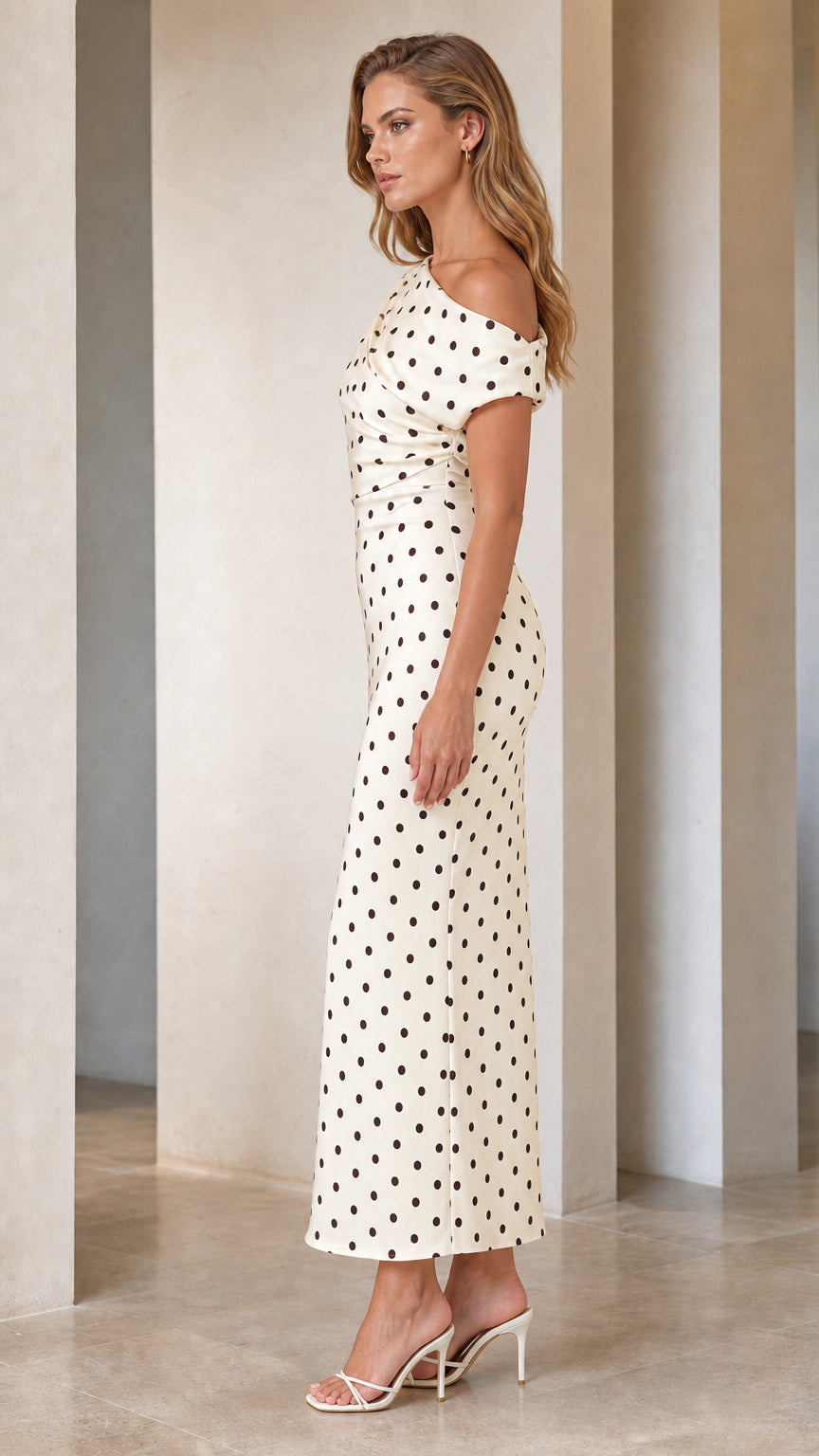 Side profile view of model in cream polka dot dress