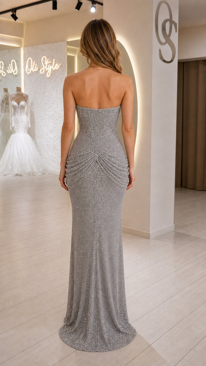 Back view of model showcasing draped back detail on silver dress