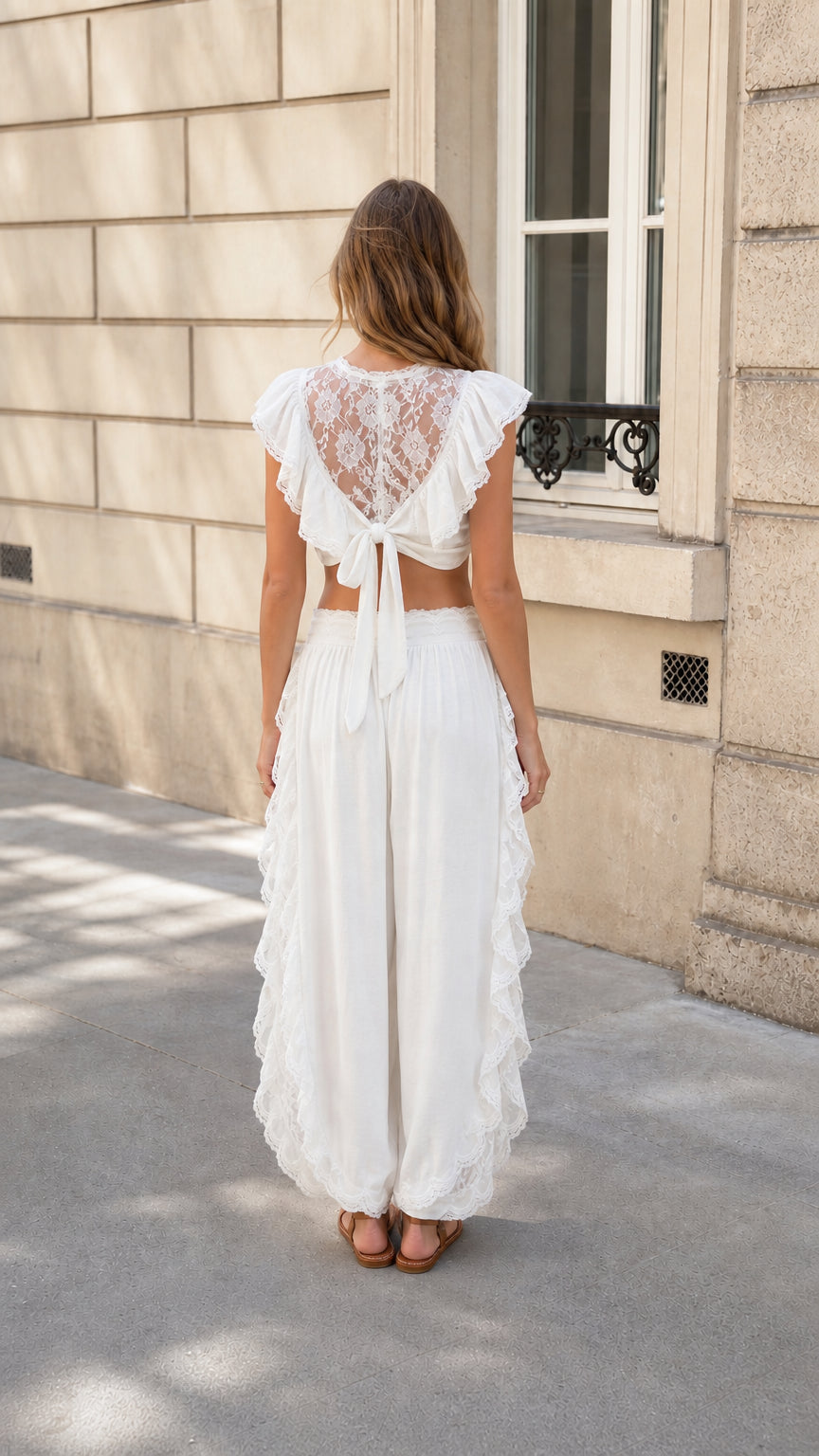 Back view of woman showing lace panel and tie detail on white crop top