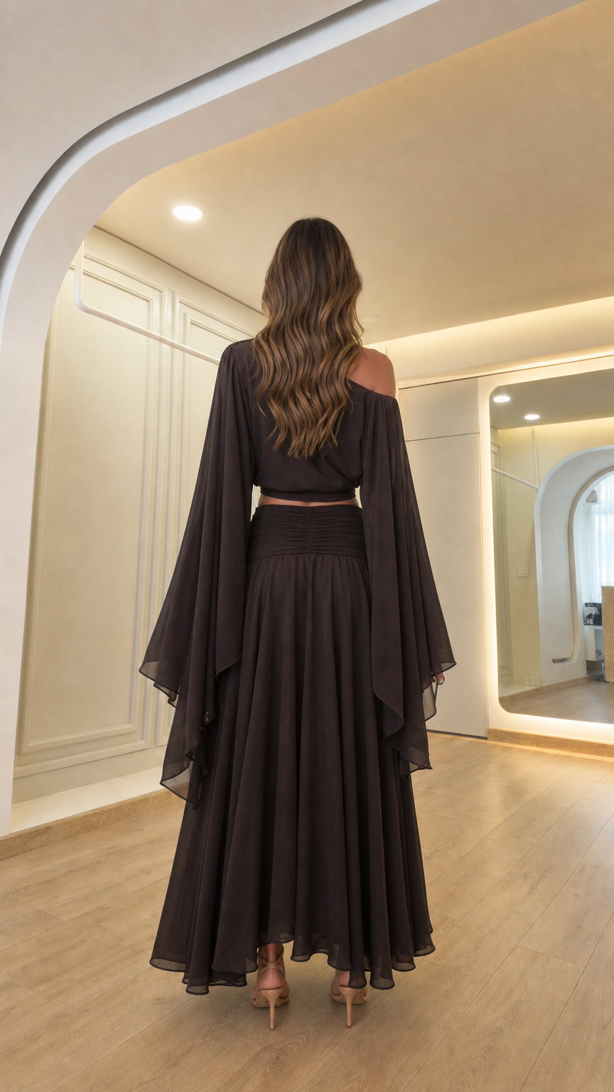 Back view of woman showcasing the draped back design of the dark brown outfit