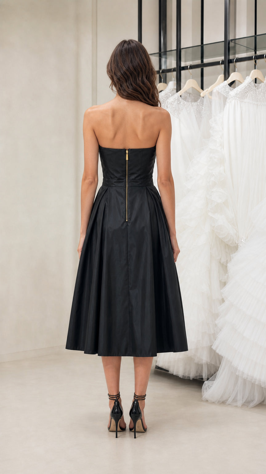 Back view of model wearing black strapless midi dress