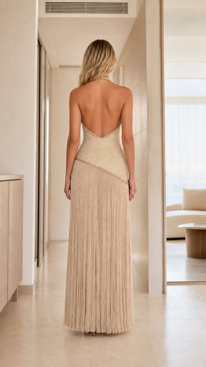 Back view showcasing backless halter design of champagne dress