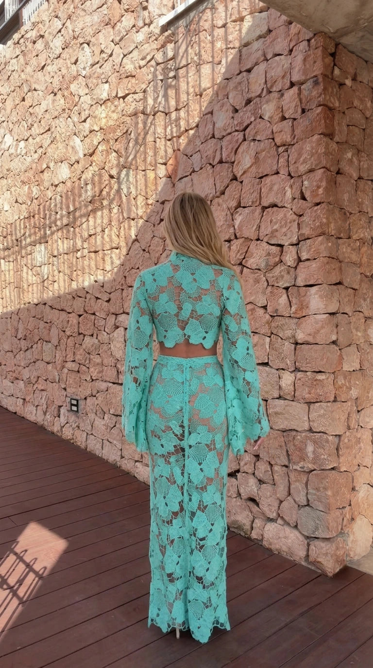 Back view of model in turquoise crochet crop top and maxi skirt