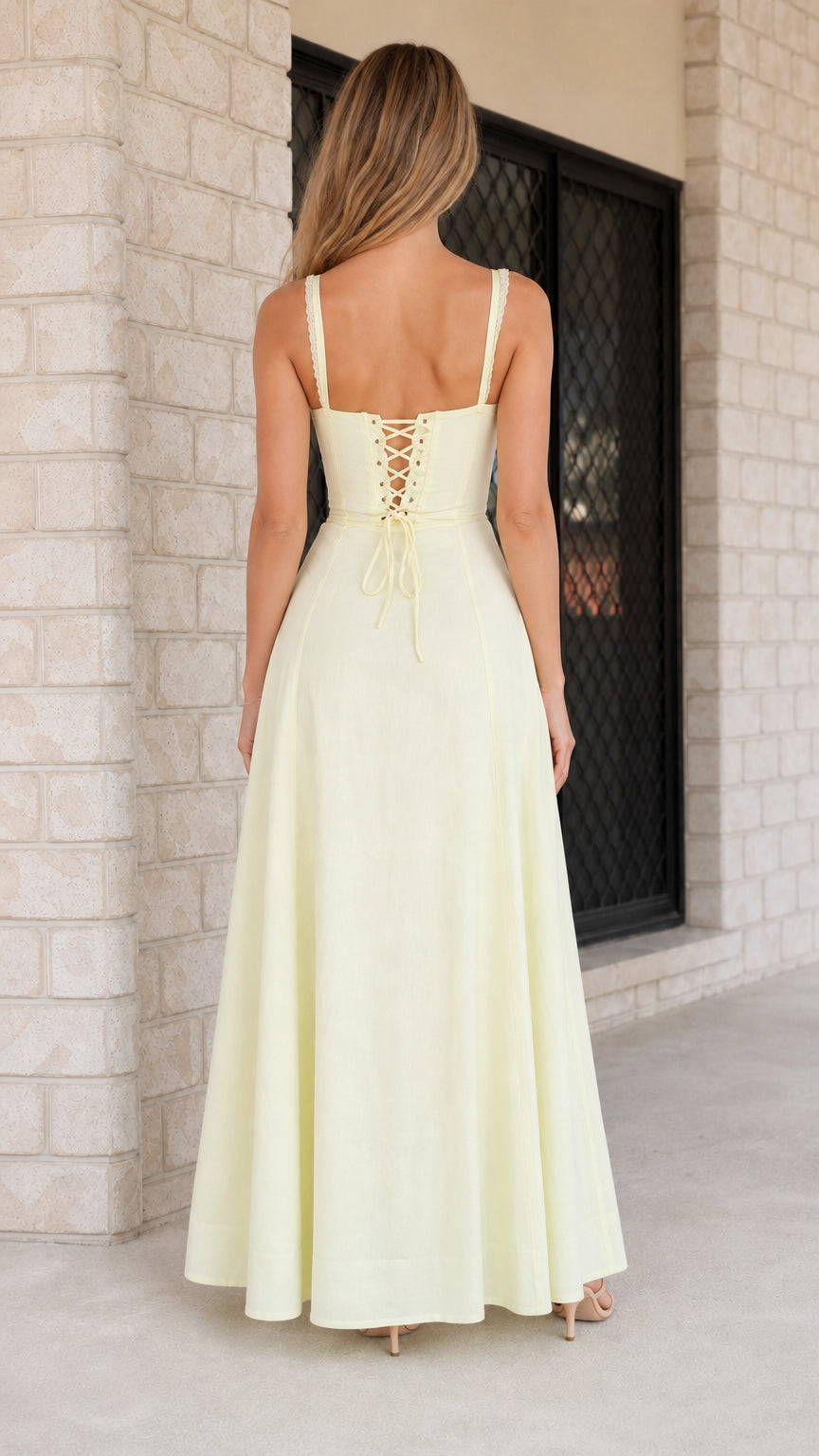 Back view highlighting corset lace-up detail on yellow maxi dress