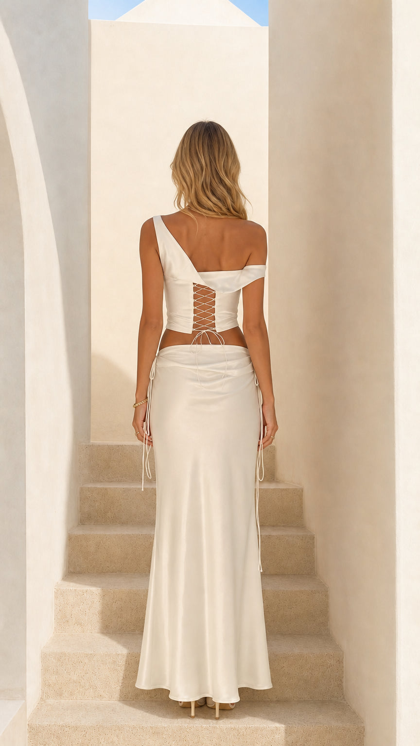 Back view of woman showing lace-up back detail on white satin top