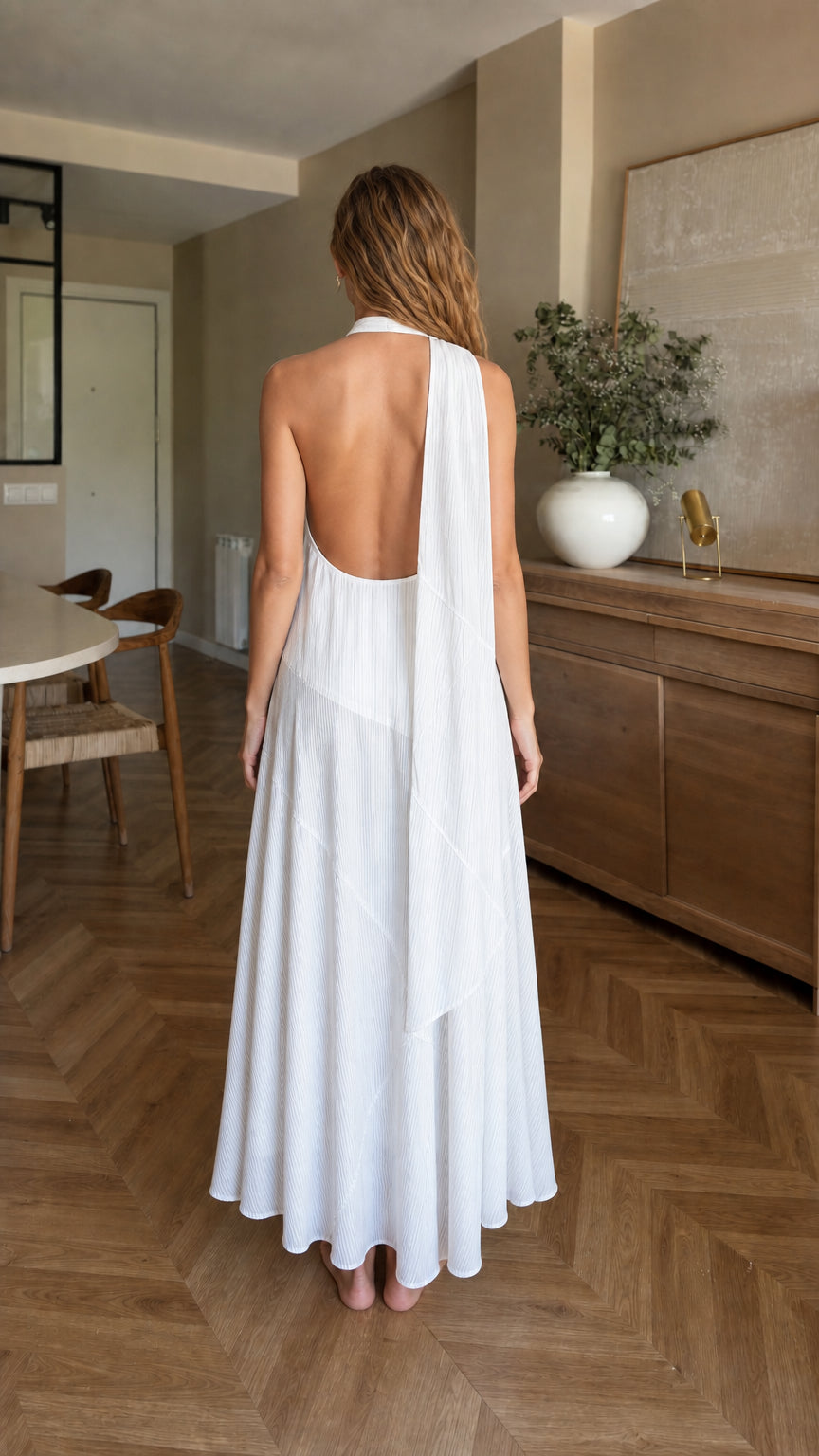Back view of woman showing open back detail on white maxi dress