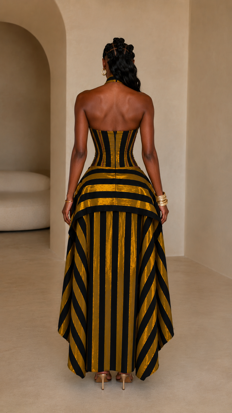 Back view of mustard and black striped halter maxi dress with flowing skirt