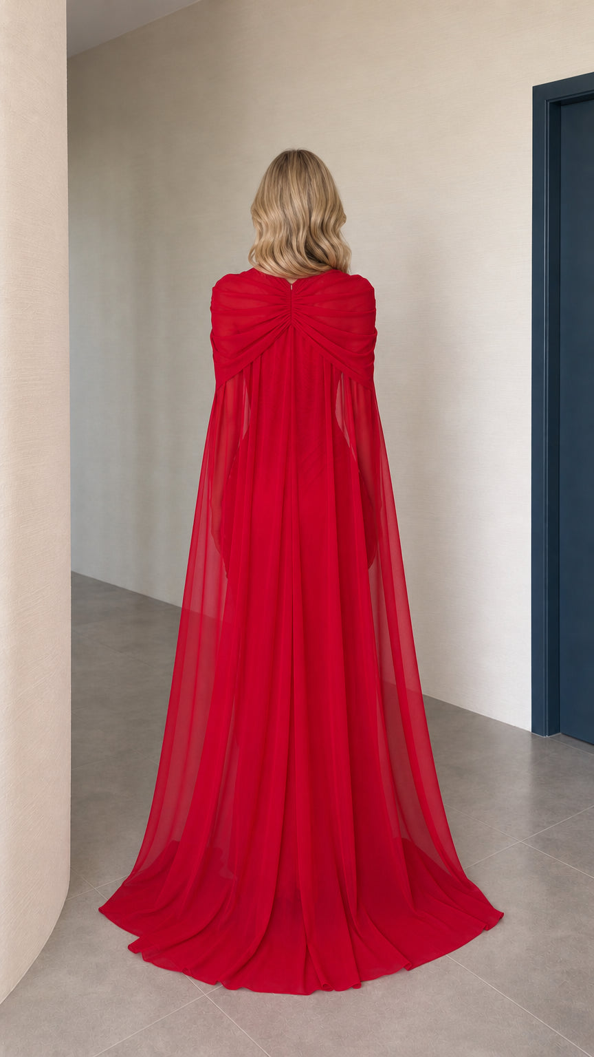 Back view showing flowing cape overlay on red dress