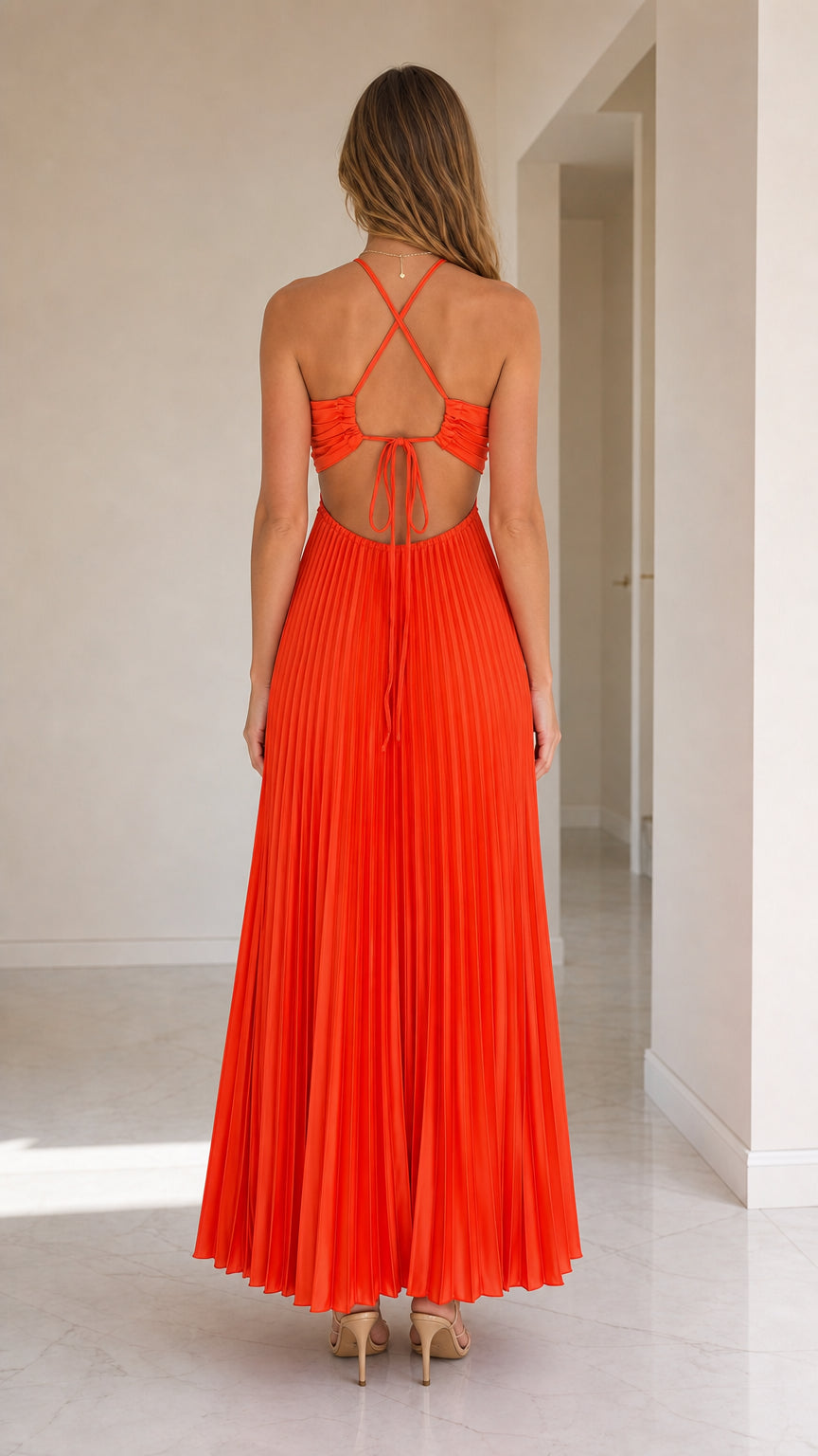 Back view of model showing lace-up open back on orange maxi dress