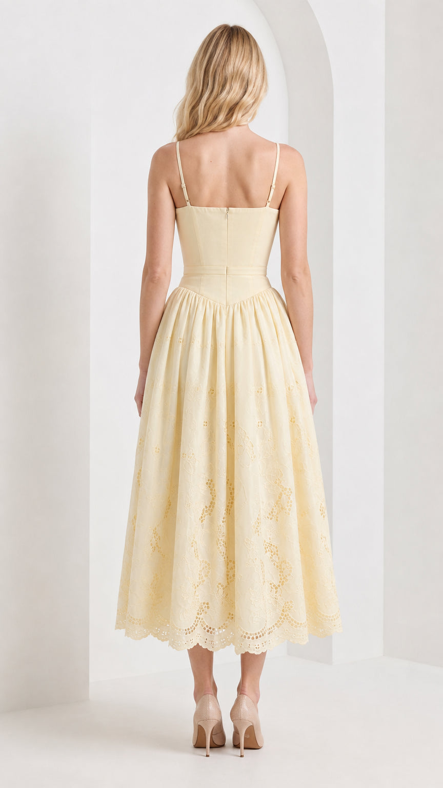 Back view of model wearing yellow embroidered midi dress
