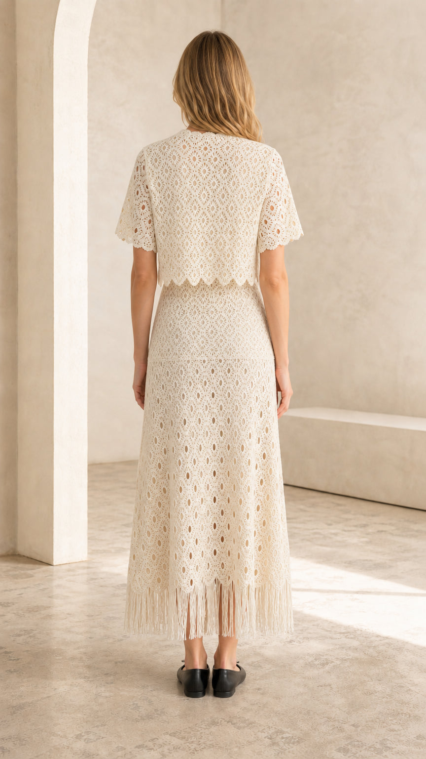 Back view of ivory crochet lace two-piece set showing fringe hem