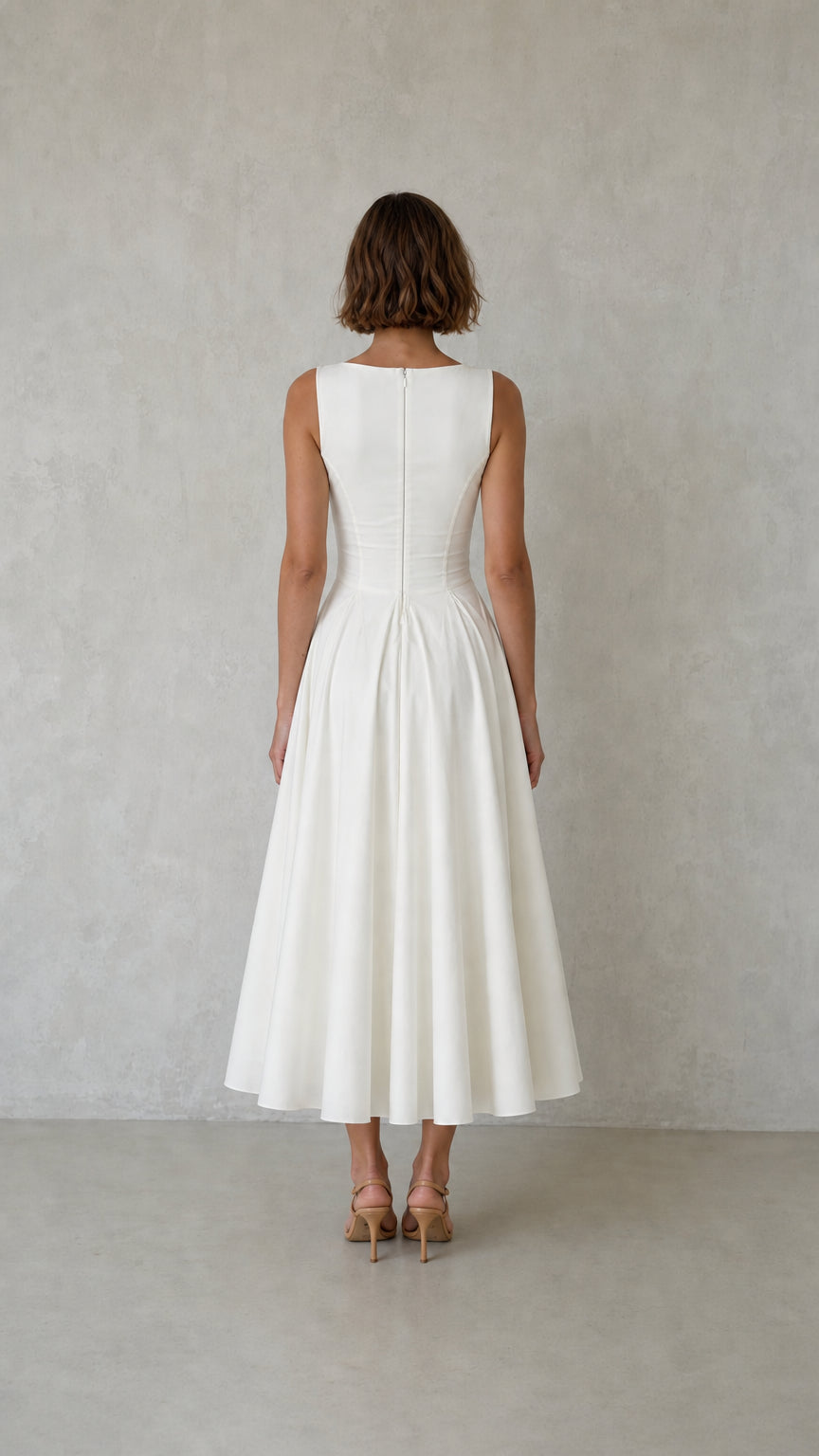 Back view of woman wearing white pleated dress