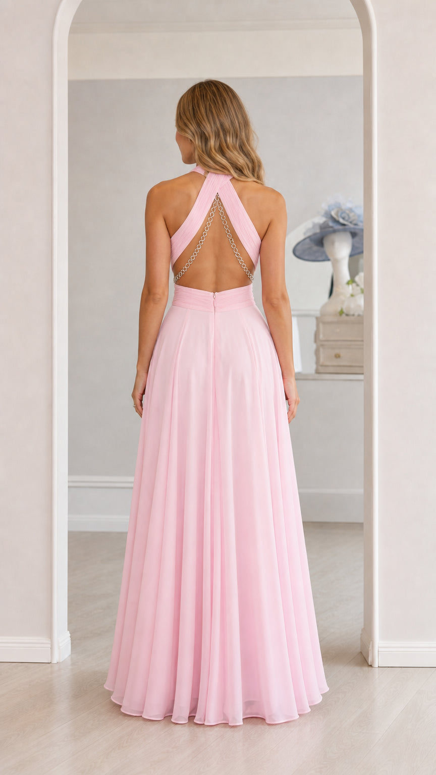 Model wearing pink chiffon halter maxi dress showcasing open back, back view