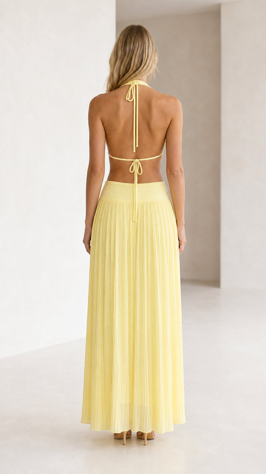 Back view of yellow halter neck cutout pleated maxi dress