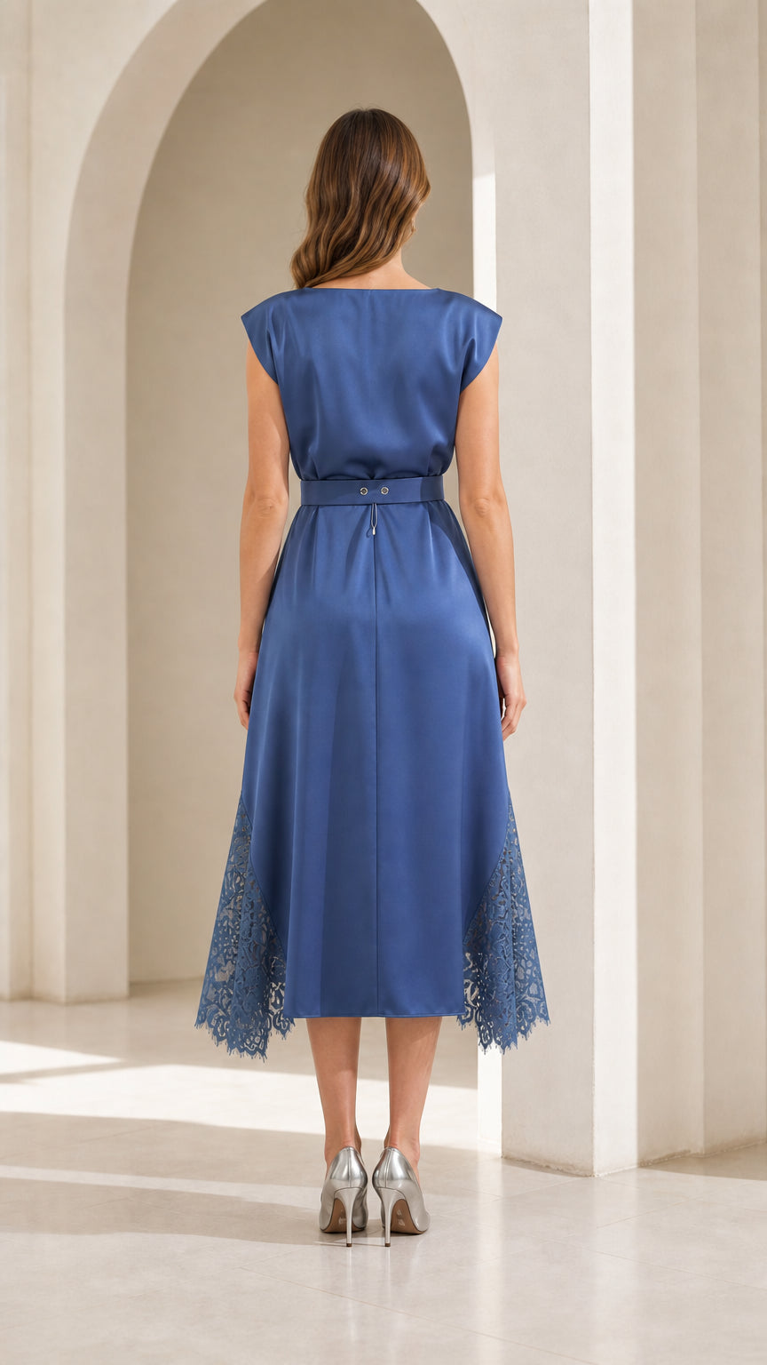 Back view of model in blue satin midi dress with belted waist
