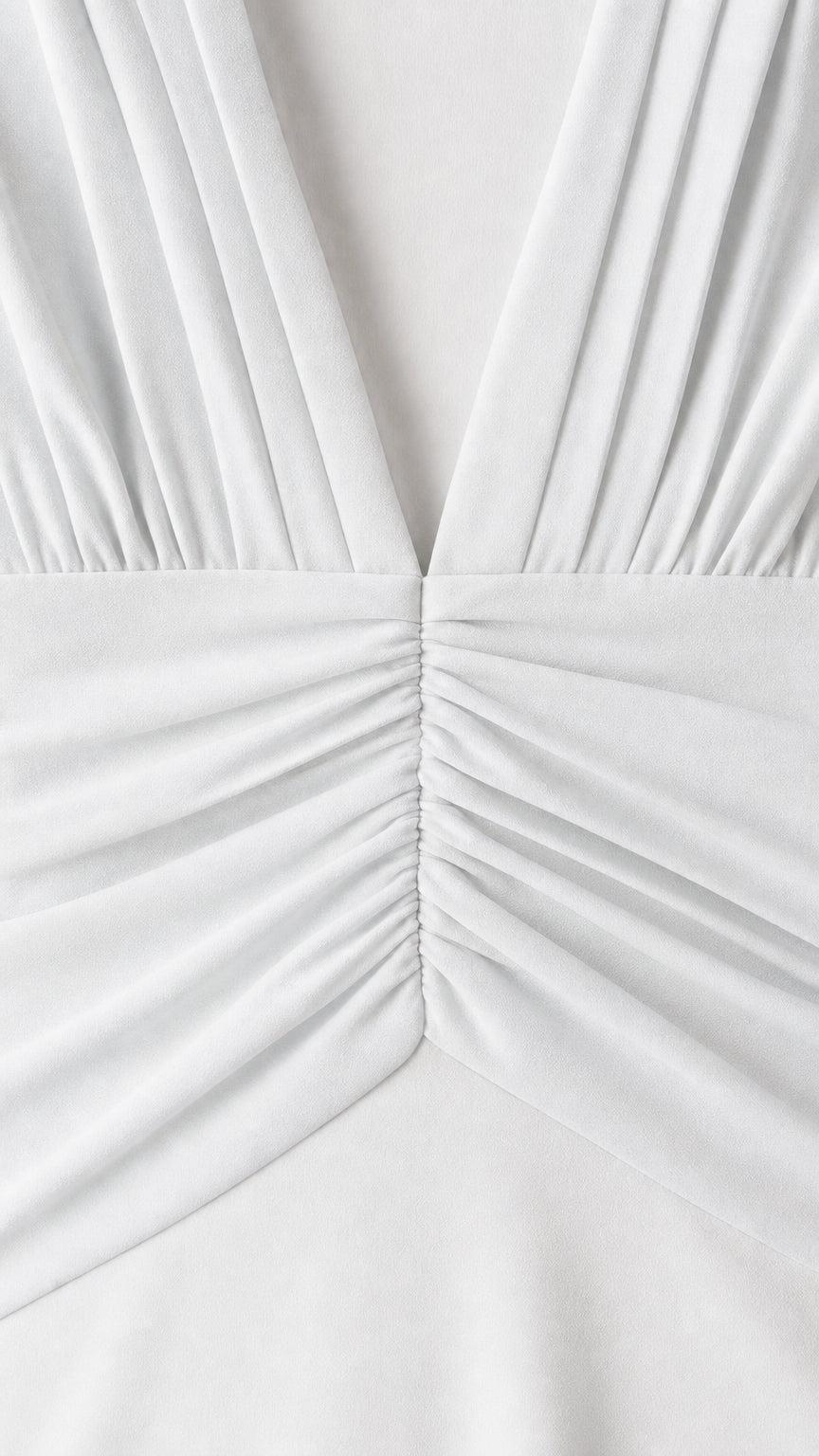 Close-up detail of pleated V-neck and ruched waist on white dress