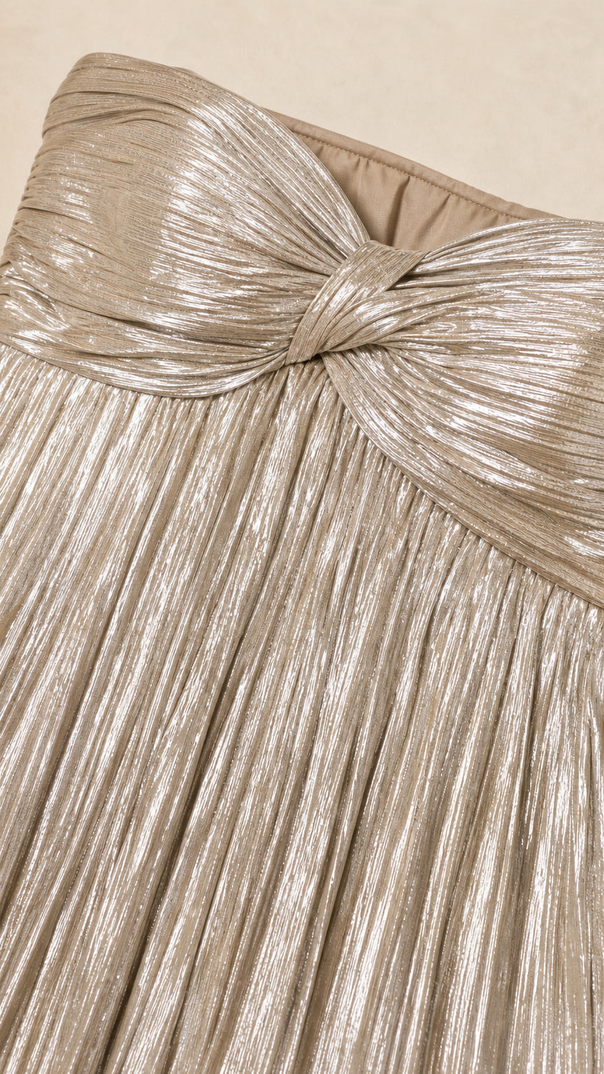 Close-up of knotted sweetheart bodice detail on gold metallic dress