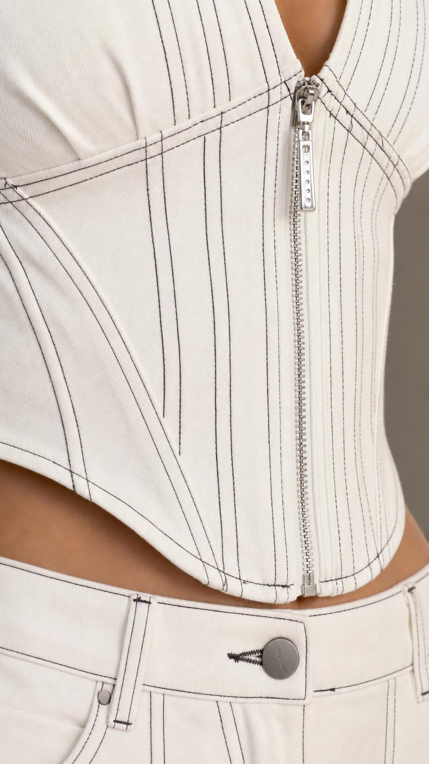 Close-up of ivory top front zipper, vertical seams, and matching pants waistband
