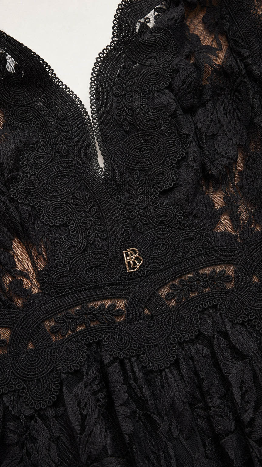 Close-up of plunging neckline and hardware detail on black dress