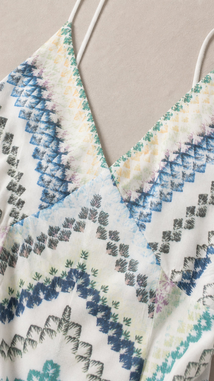 Close-up detail of V-neckline and white sequin fabric pattern