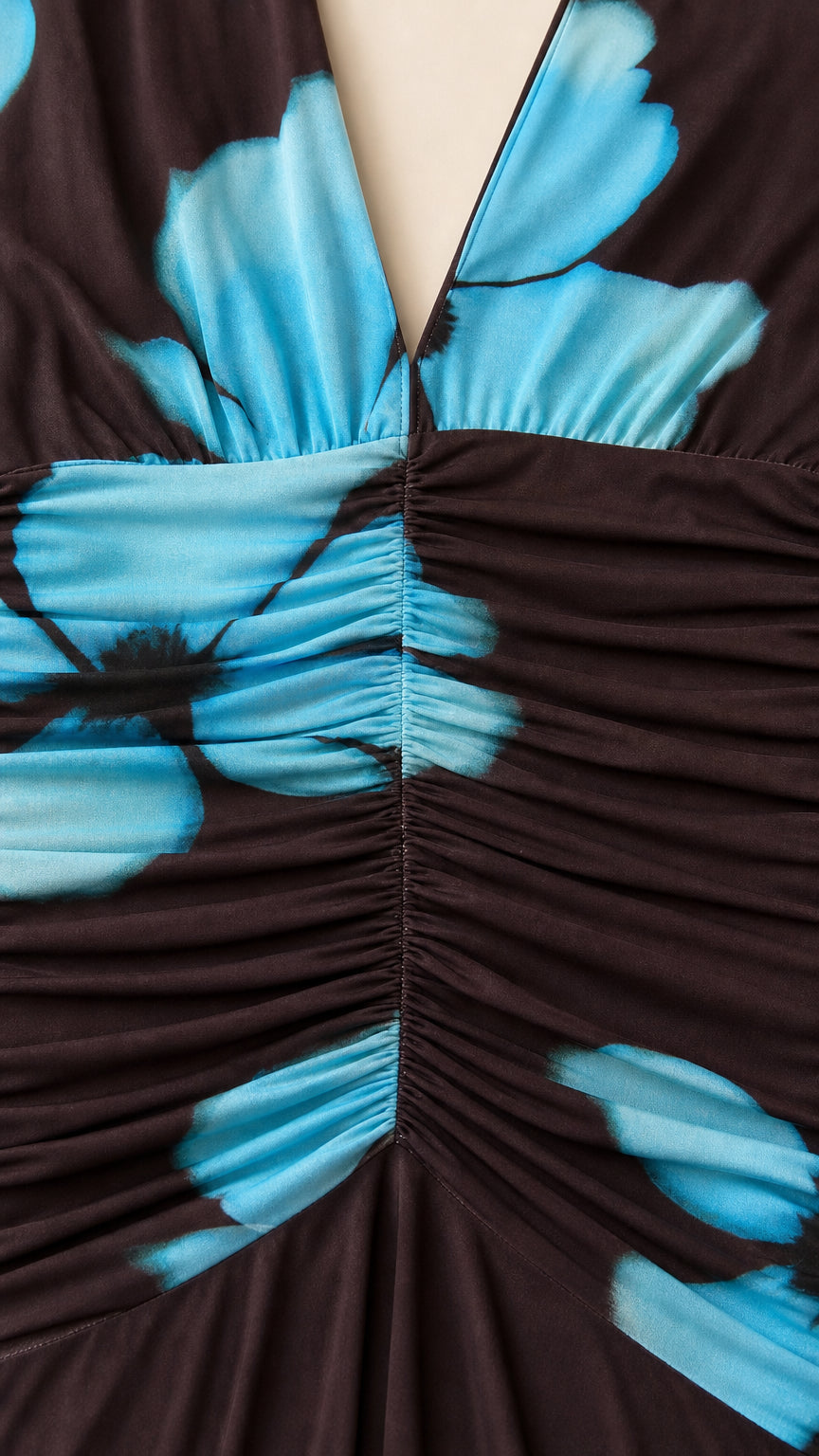 Close-up detail of front ruching and blue floral pattern on dress