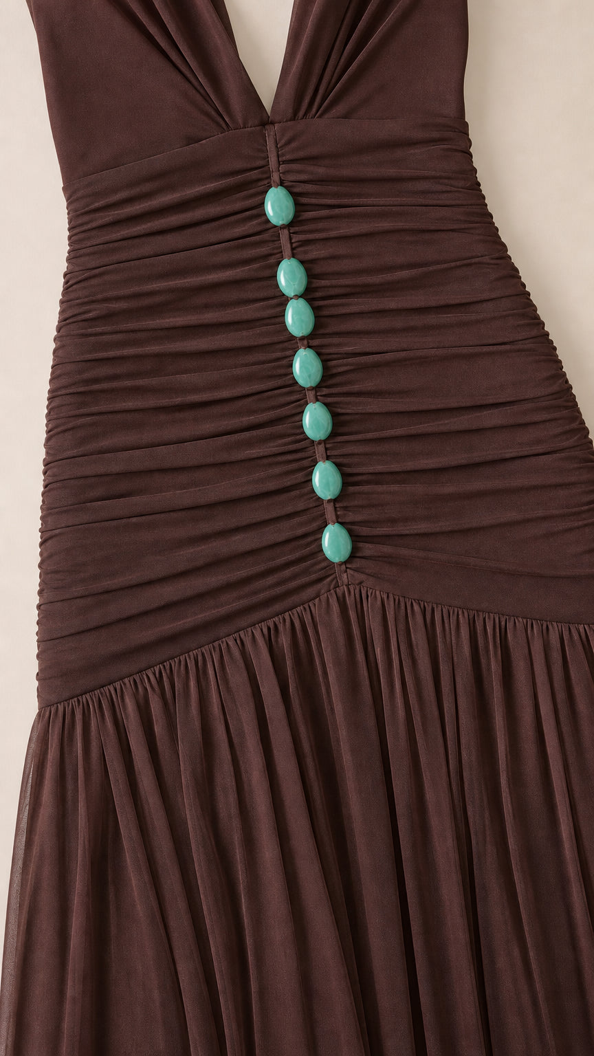 Close-up detail of bodice ruching and buttons on brown dress